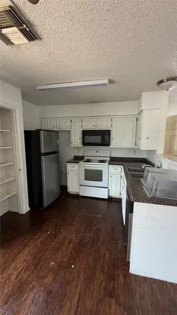 a kitchen with stainless steel appliances a stove a sink and a refrigerator