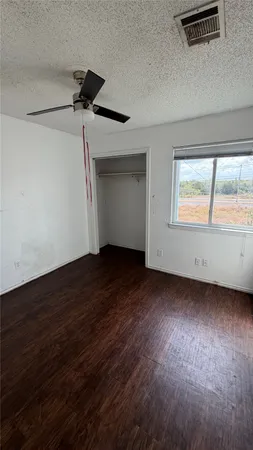 a view of a livingroom with wooden floor and a ceiling fan