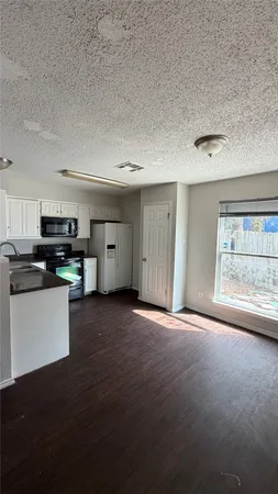 a view of an empty room with a kitchen