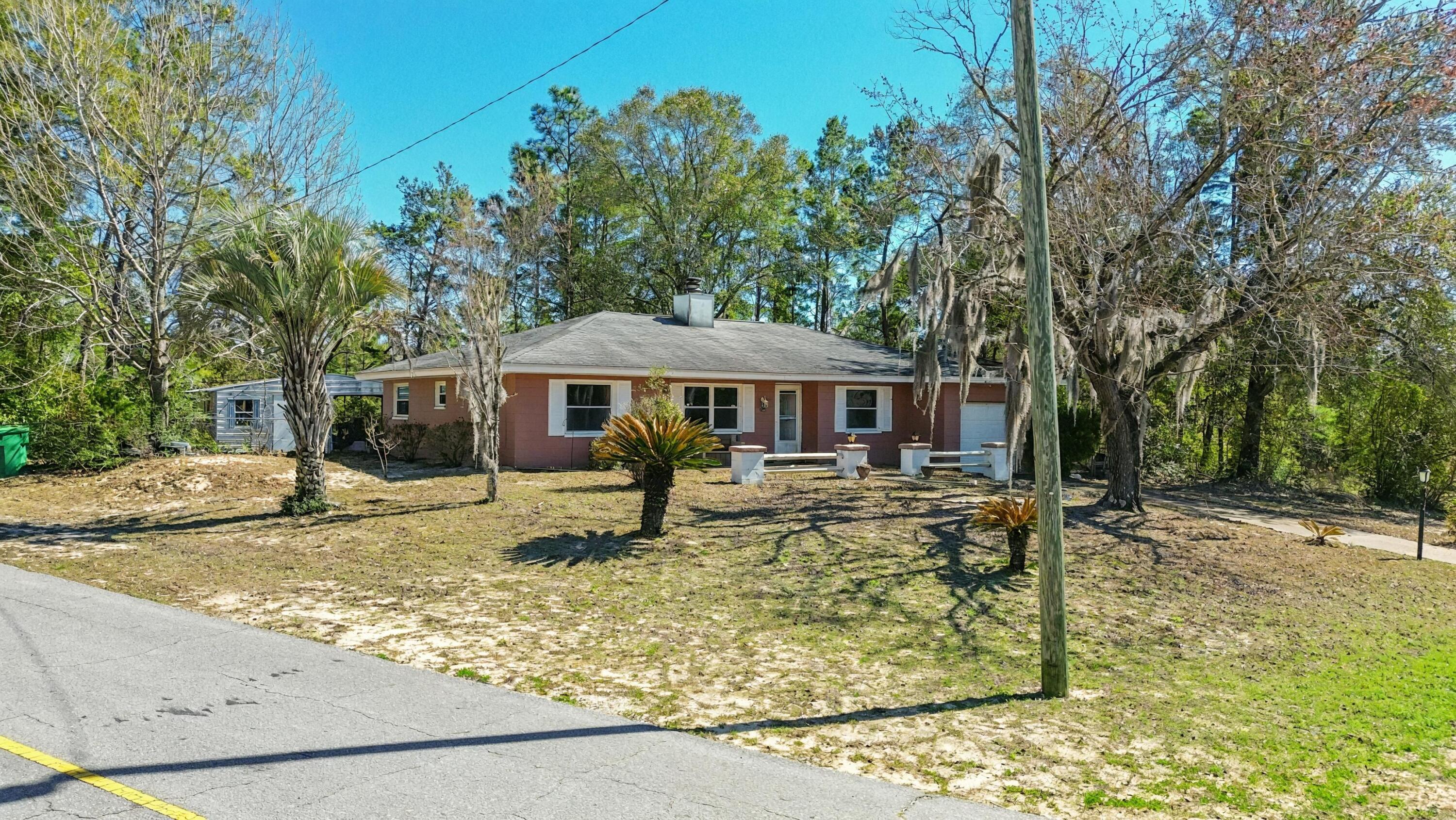 4335 Country Club Boulevard Chipley, FL 32428 - Photo 1 of 28 front view of a house with a yard table and chairs