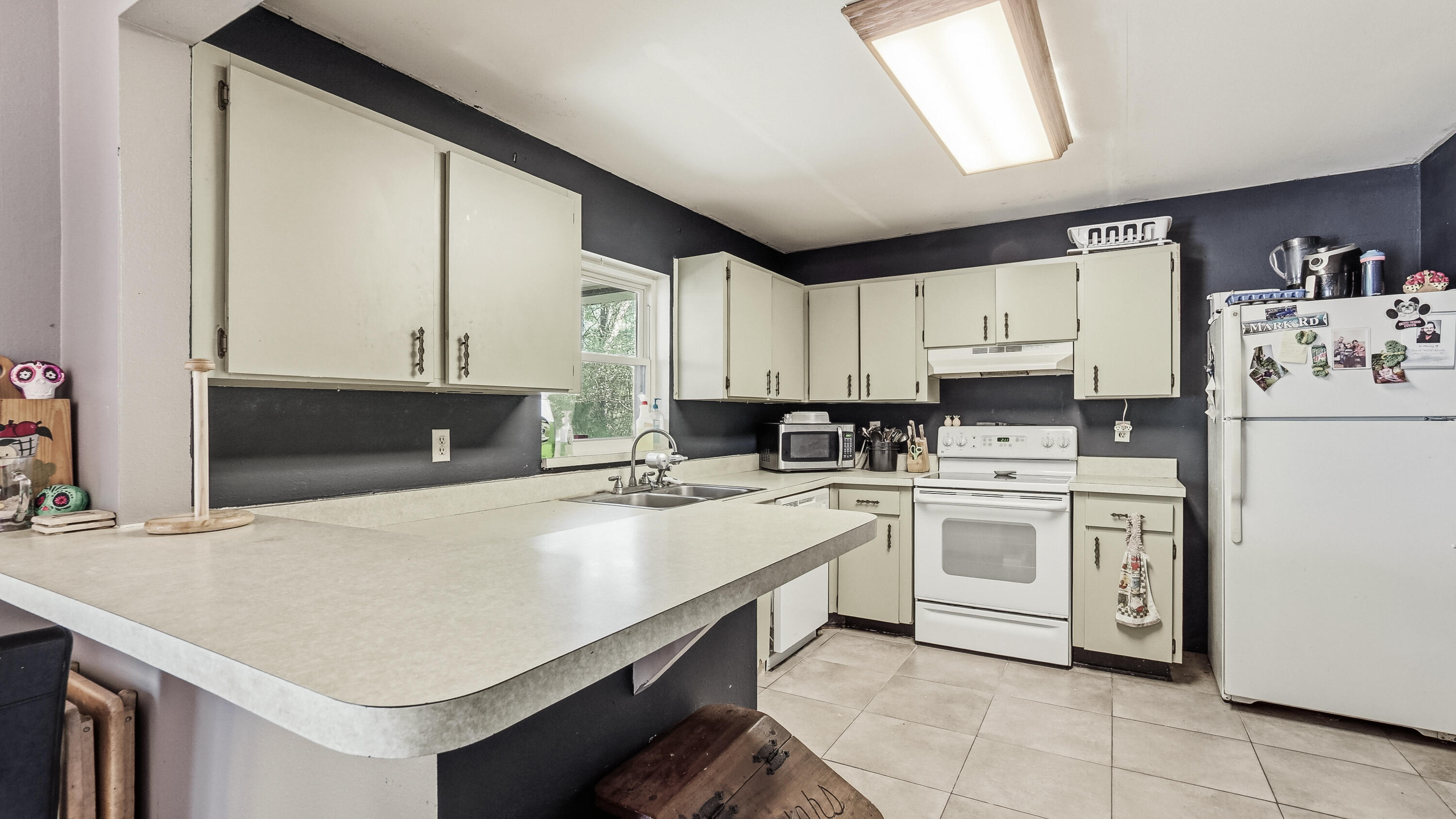 4335 Country Club Boulevard Chipley, FL 32428 - Photo 15 of 28 a kitchen with a sink a stove and white cabinets