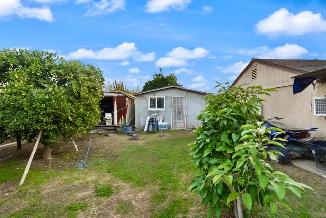 a view of a house with a backyard and a tree