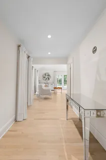 a view of a hallway with wooden floor and furniture