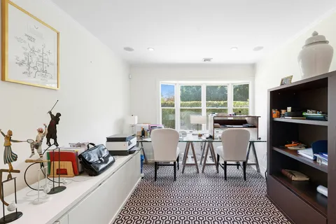 a living room with furniture a flat screen tv and a floor to ceiling window