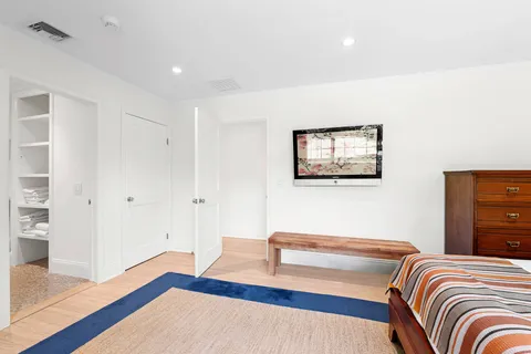 a bedroom with a bed and a wooden floor