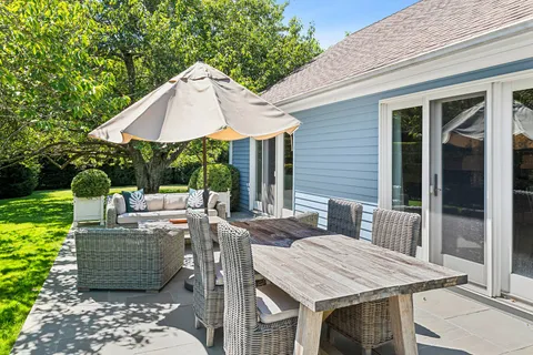 a view of a patio with table and chairs under an umbrella
