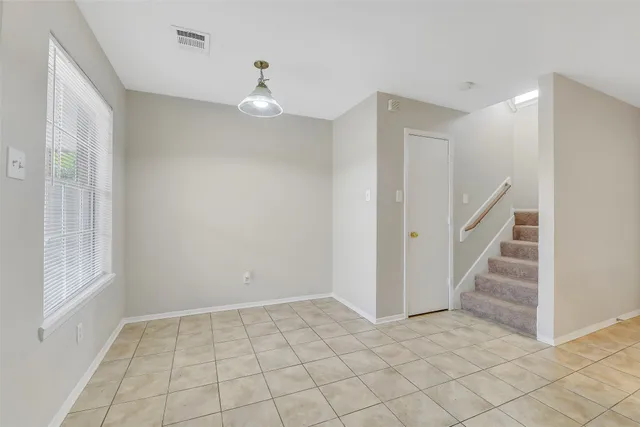 an empty room with a window and a fan