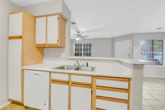 a view of an empty room with window and chandelier fan