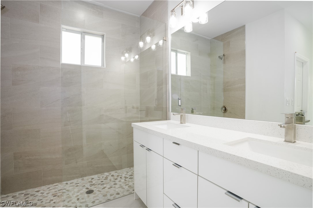 3233 Ruth Lane Lehigh Acres, FL 33976 - Photo 13 of 23 a bathroom with a sink a shower and a mirror