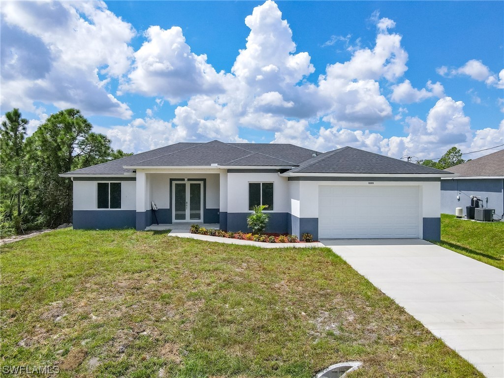 3233 Ruth Lane Lehigh Acres, FL 33976 - Photo 2 of 23 a front view of house with yard and trees in the background