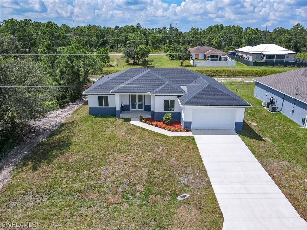 3233 Ruth Lane Lehigh Acres, FL 33976 - Photo 21 of 23 an aerial view of a house with swimming pool garden and mountain view