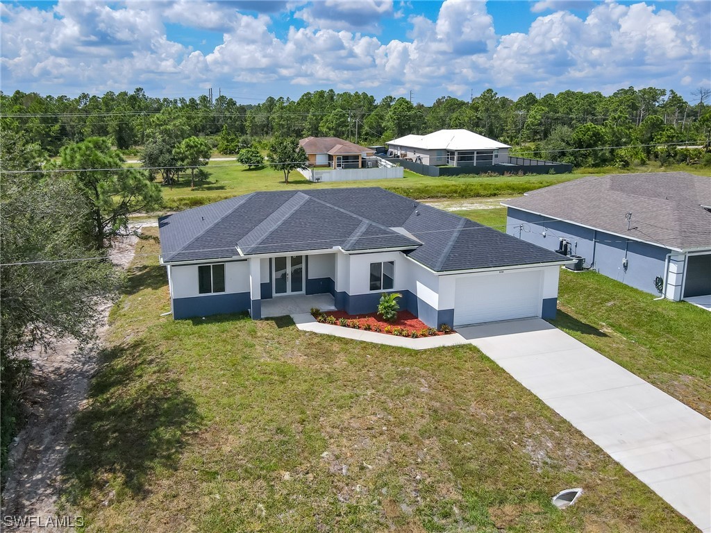 3233 Ruth Lane Lehigh Acres, FL 33976 - Photo 22 of 23 an aerial view of a house with swimming pool and mountains in the background