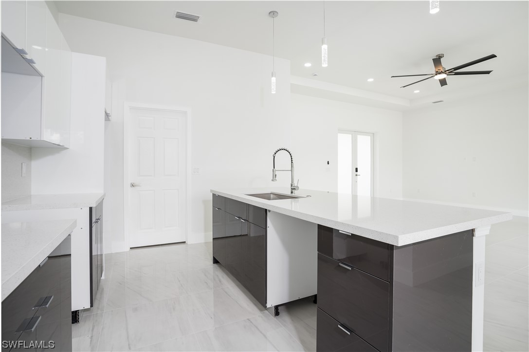 3233 Ruth Lane Lehigh Acres, FL 33976 - Photo 8 of 23 a kitchen with a sink a stove a refrigerator and cabinets
