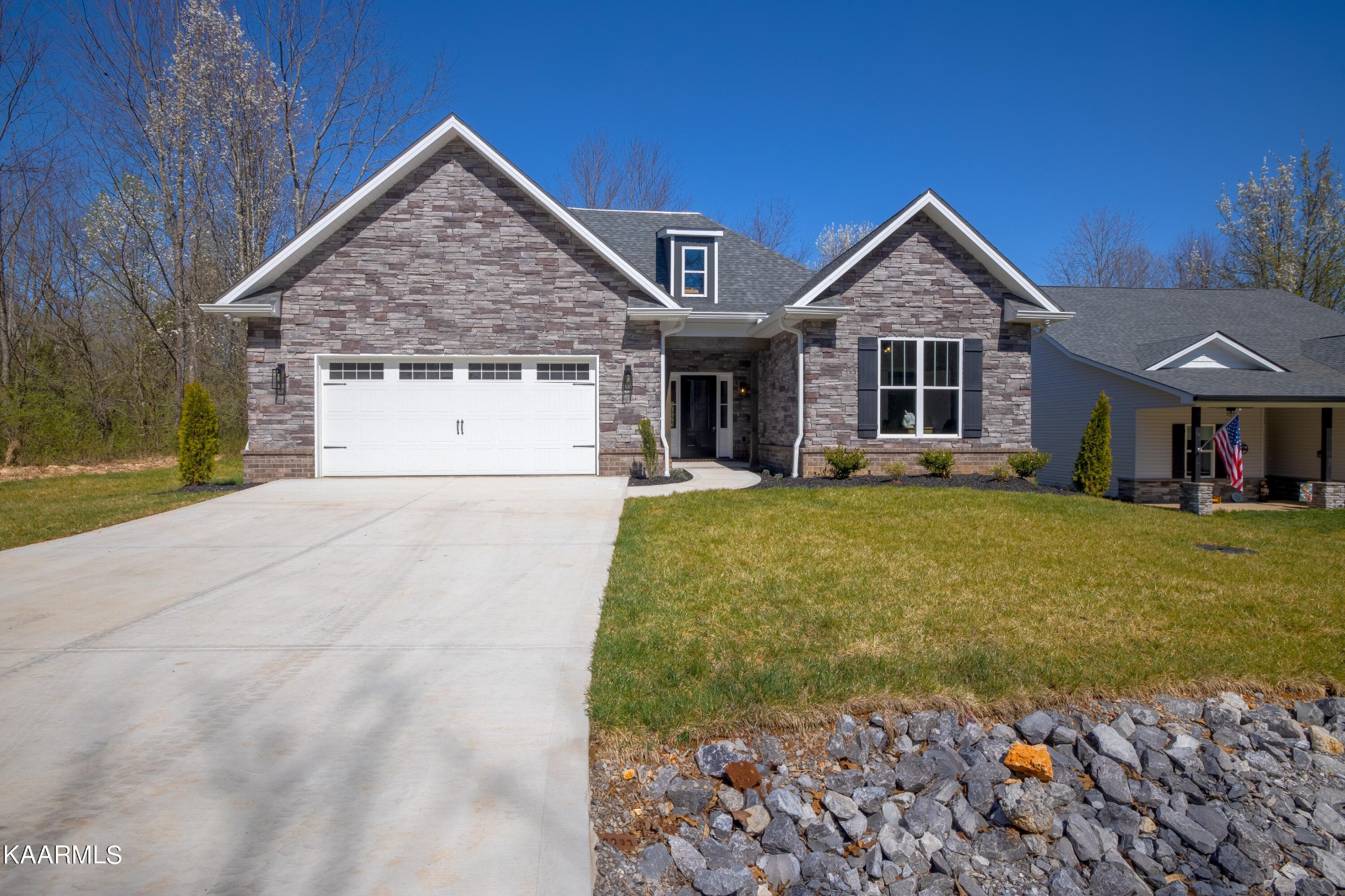a front view of a house with a yard and trees
