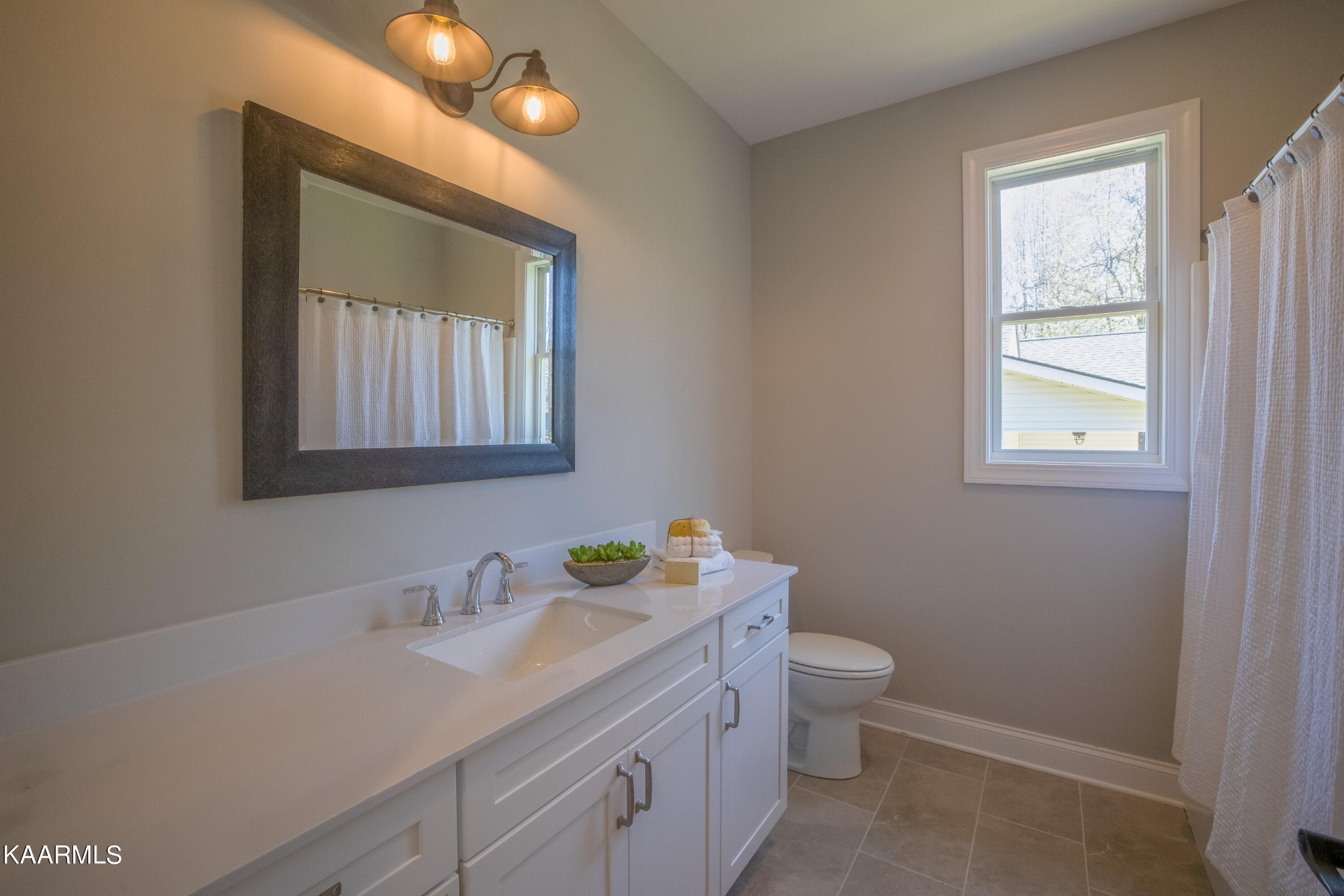 162 Tsuhdatsi Way Loudon, TN 37774 - Photo 32 of 38 a bathroom with a granite countertop sink a large mirror a toilet and a window