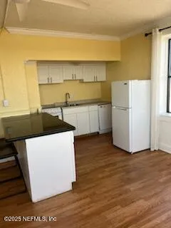 a kitchen with a wooden floor and white appliances