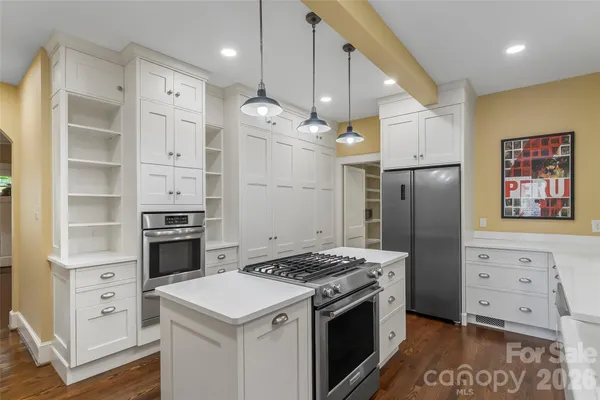 a kitchen with stainless steel appliances a stove a refrigerator and cabinets