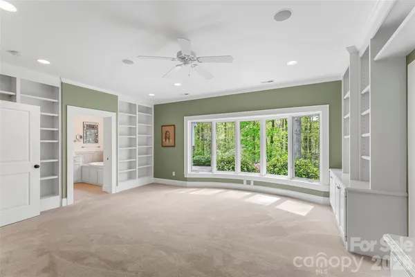 a view of an empty room with a window and a kitchen