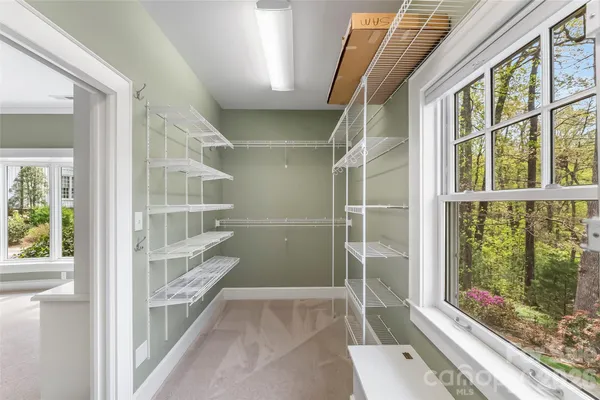 a view of walk in closet with empty racks