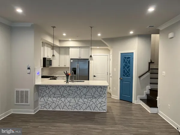 a large kitchen with kitchen island a counter top space stainless steel appliances and cabinets