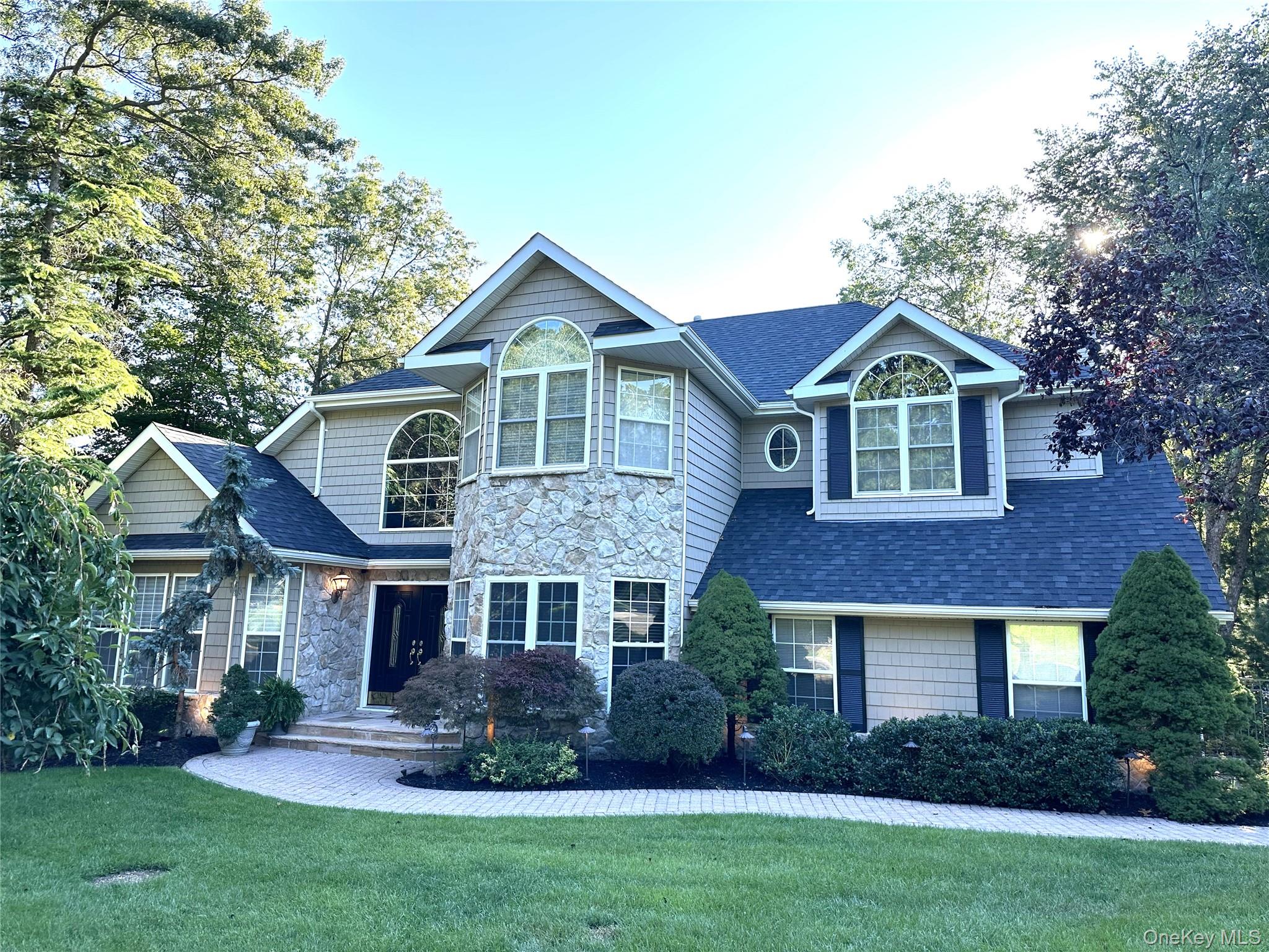 a front view of a house with a yard and trees
