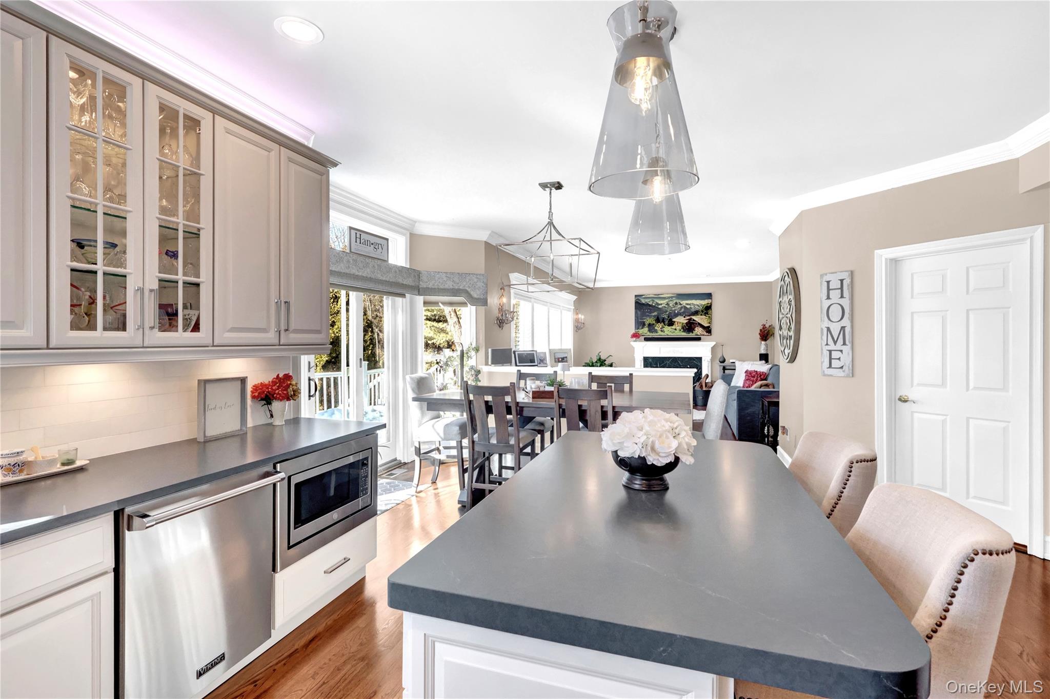 5 Frost Valley Road Mount Sinai, NY 11766 - Photo 17 of 49 a view of a dining room and livingroom with furniture wooden floor a chandelier