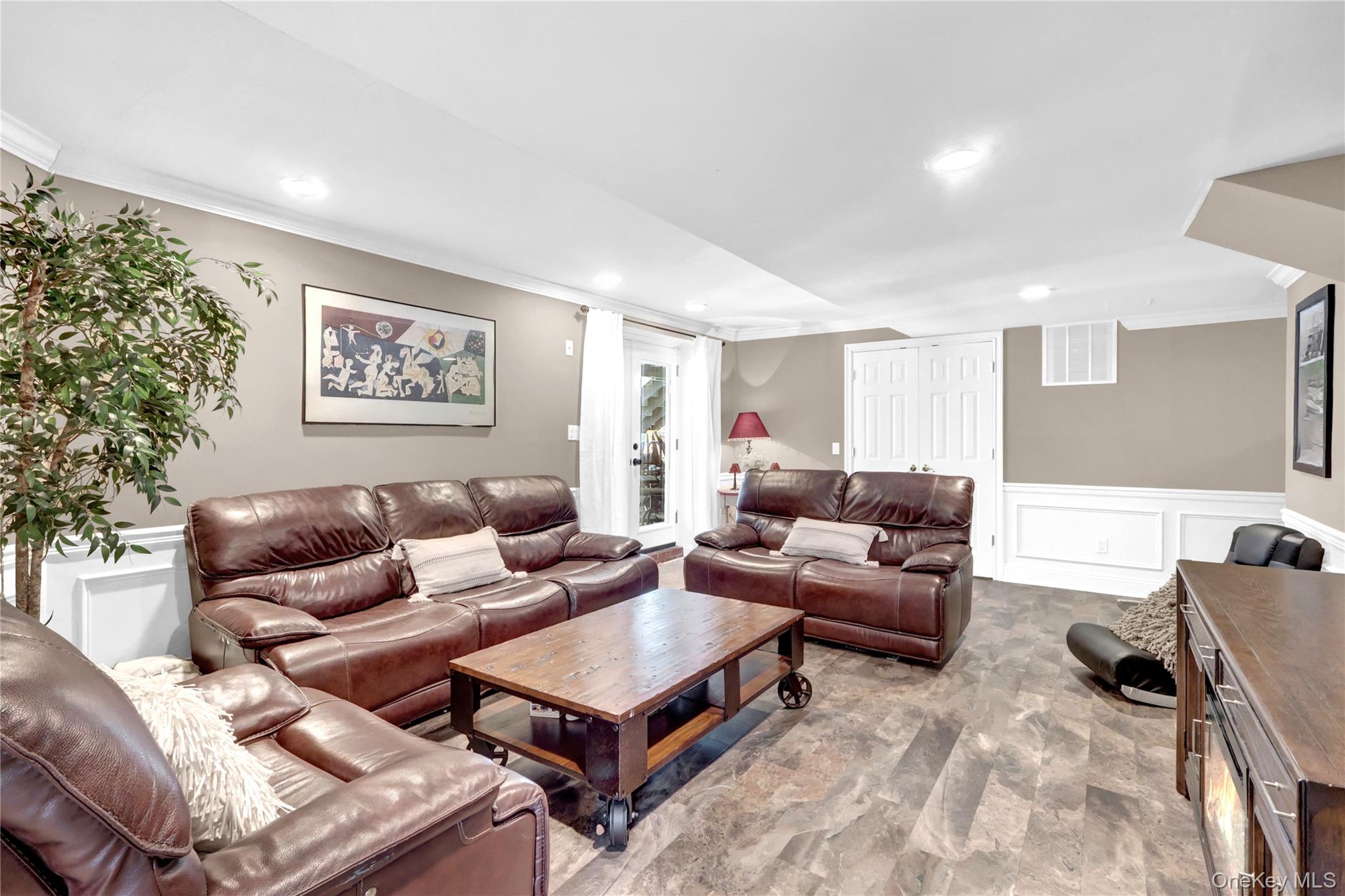 5 Frost Valley Road Mount Sinai, NY 11766 - Photo 31 of 49 a living room with furniture a rug and a painting on the wall
