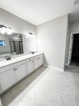 a spacious bathroom with a double vanity sink and a mirror