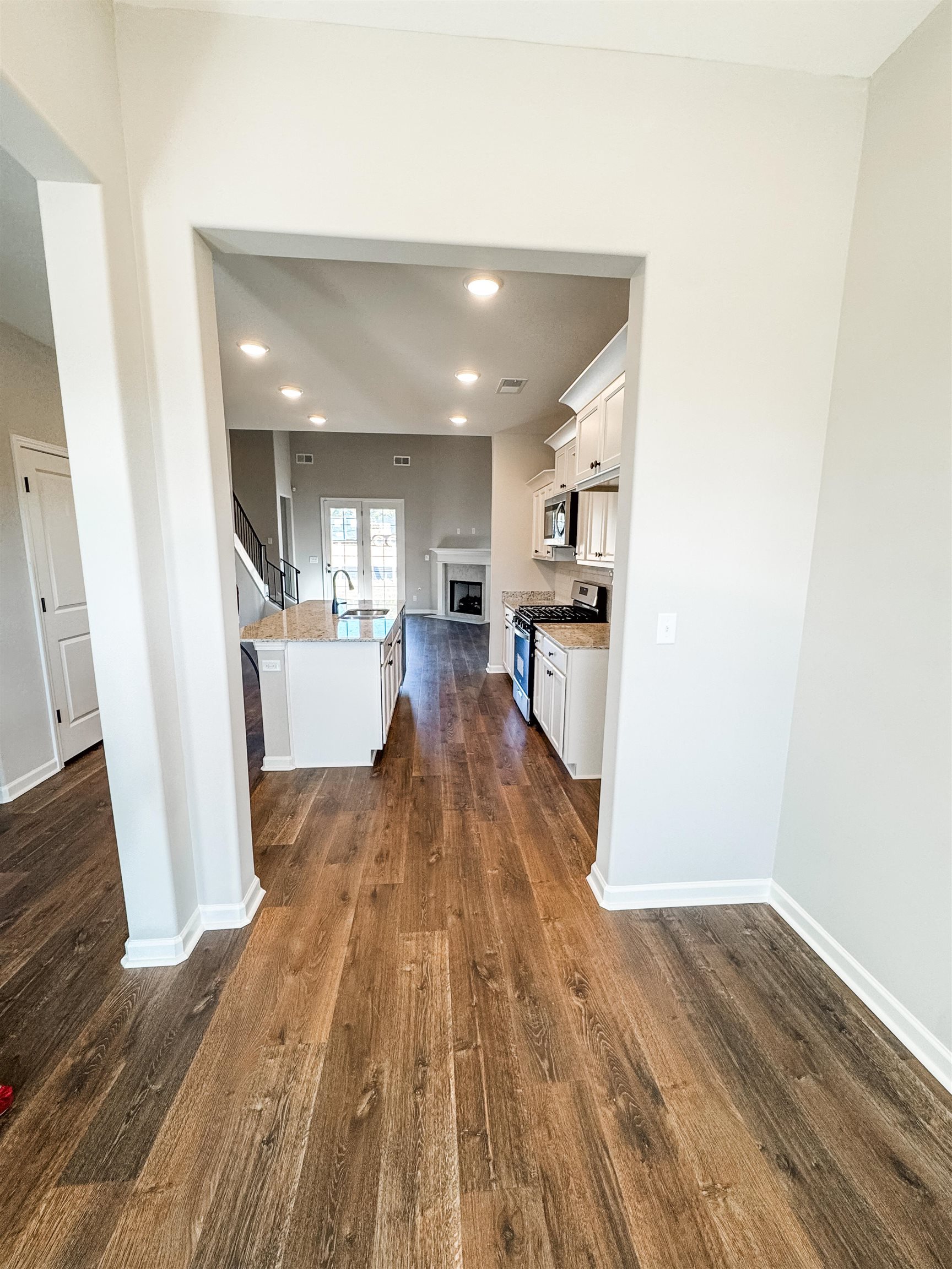 400 Maple Street Oakland, TN 38060 - Photo 3 of 14 Kitchen with white cabinetry, sink, stainless steel appliances, dark hardwood / wood-style flooring, and an island with sink