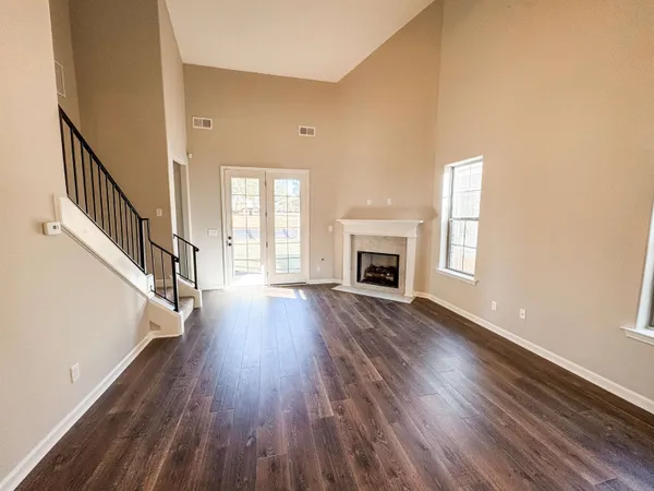a view of empty room with wooden floor and fireplace
