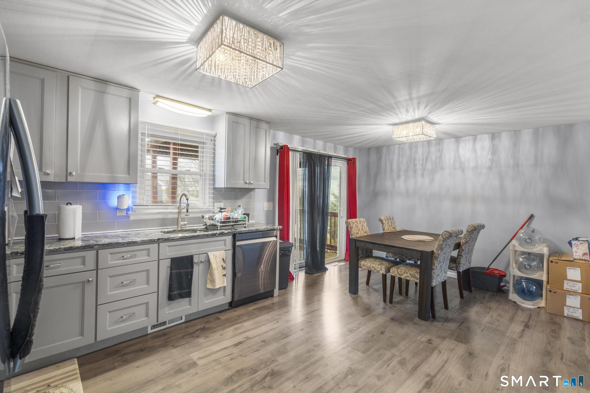 7 Pettit Drive Meriden, CT 06451 - Photo 14 of 35 a kitchen with stainless steel appliances granite countertop a stove top oven a sink dishwasher and a dining table with wooden floor