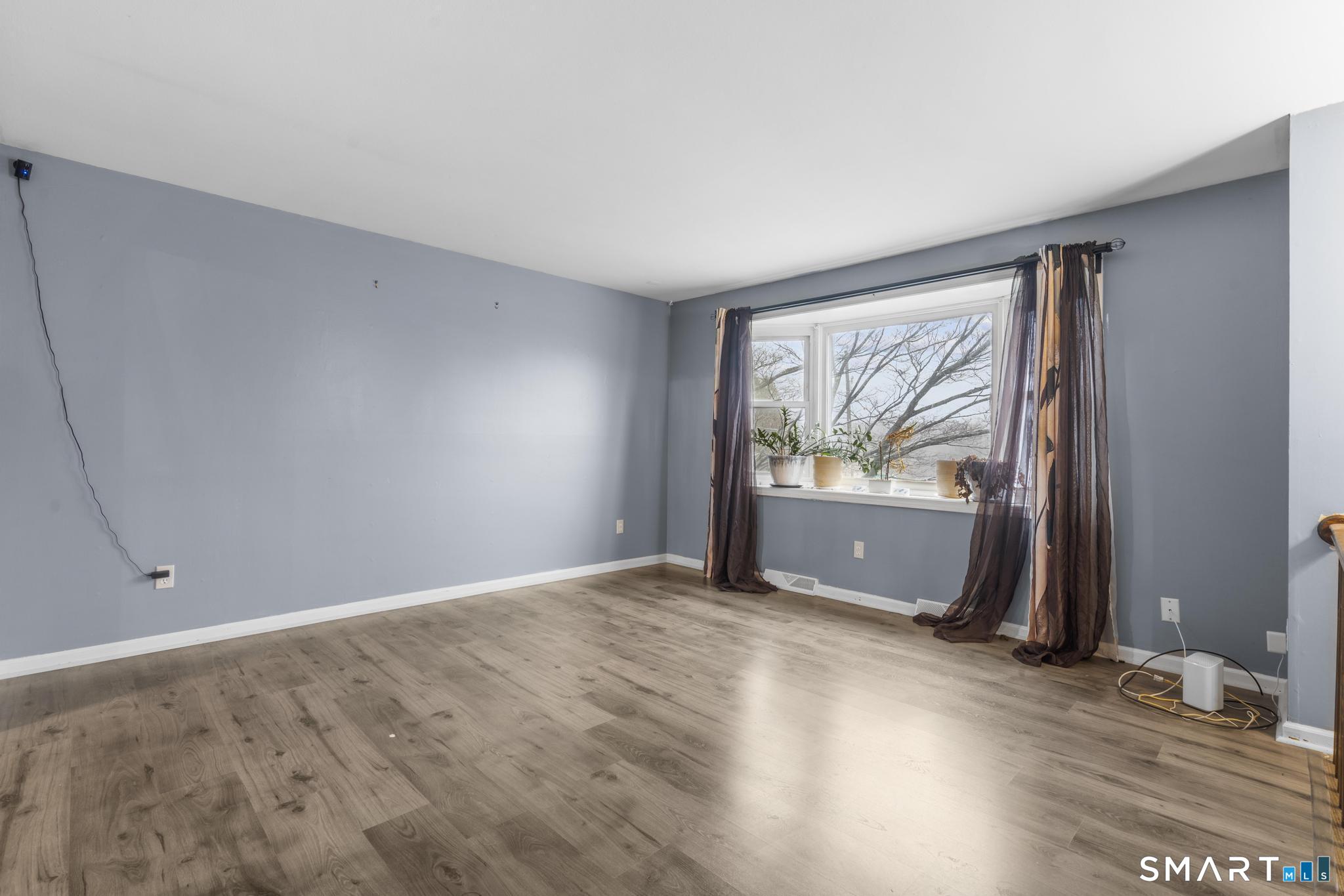 7 Pettit Drive Meriden, CT 06451 - Photo 9 of 35 a view of an empty room with wooden floor and a window