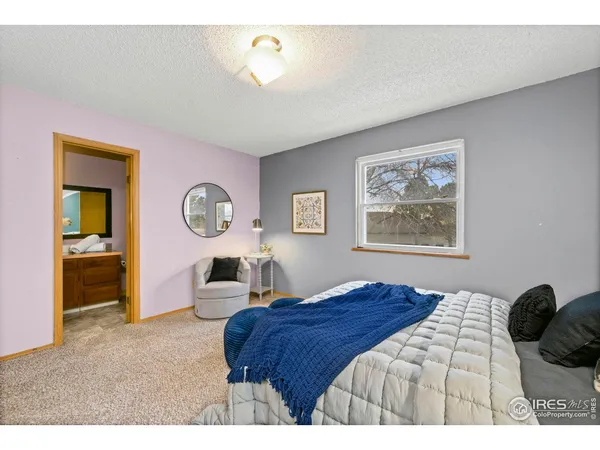a bedroom with a bed and a large mirror on the dresser