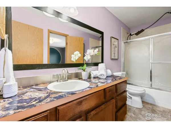a bathroom with a granite countertop sink mirror vanity and toilet
