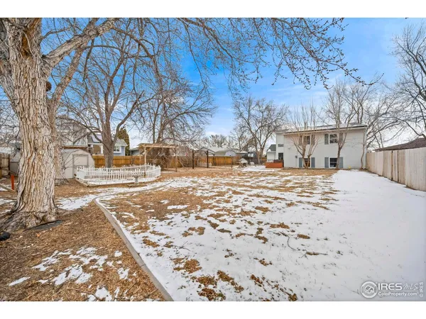 a view of a house with backyard and trees