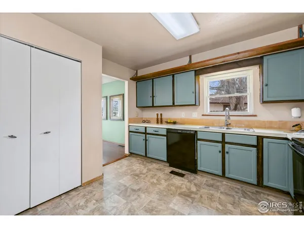 a kitchen with granite countertop a sink cabinets and stainless steel appliances