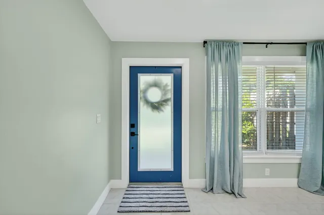a view of a hallway with wooden floor and a livingroom