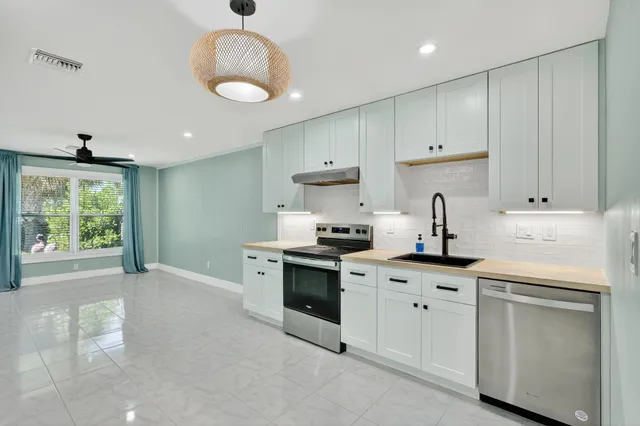 a kitchen with white cabinets and white appliances