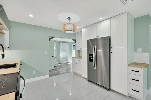 a view of a kitchen with a refrigerator and a sink