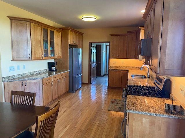 1869 East Town Line Road Oregon, IL 61061 - Photo 12 of 45 a kitchen with stainless steel appliances granite countertop a stove a sink dishwasher a refrigerator with white cabinets and wooden floor