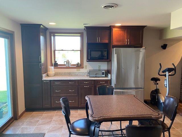 1869 East Town Line Road Oregon, IL 61061 - Photo 21 of 45 a kitchen with a table chairs refrigerator and microwave