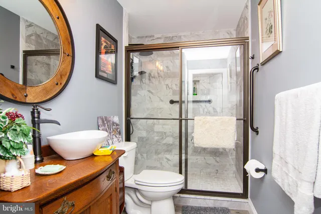 a bathroom with a granite countertop toilet and a sink