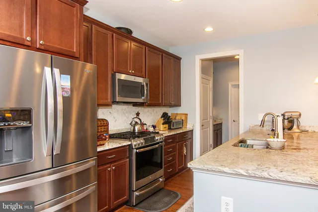 a kitchen with stainless steel appliances granite countertop a refrigerator stove and microwave