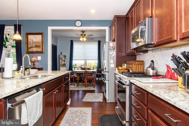a kitchen with stainless steel appliances granite countertop a sink stove and cabinets