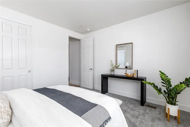 a bedroom with a bed and a potted plant