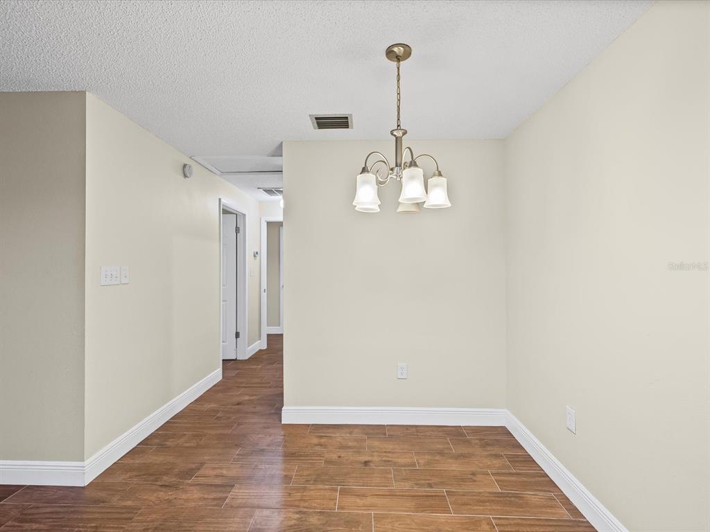 6037 Chesham Drive, Unit 7 New Port Richey, FL 34653 - Photo 12 of 29 a view of a room with a sink and chandelier