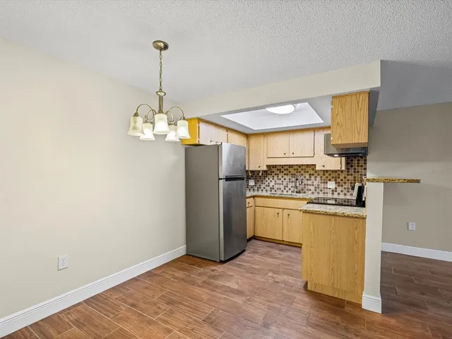 a kitchen with stainless steel appliances granite countertop a refrigerator and a stove top oven