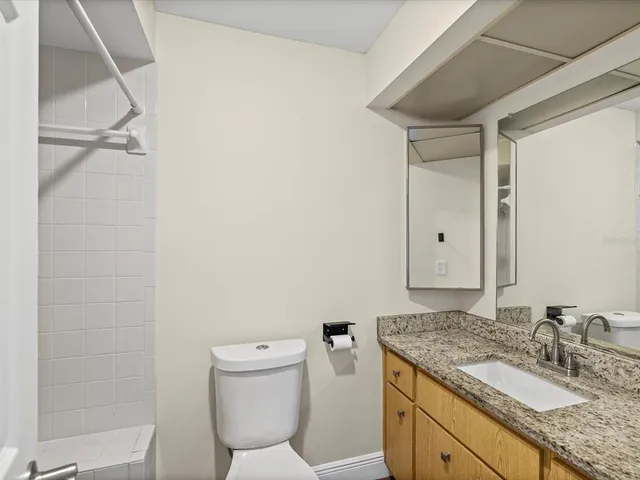 a bathroom with a granite countertop sink toilet and shower