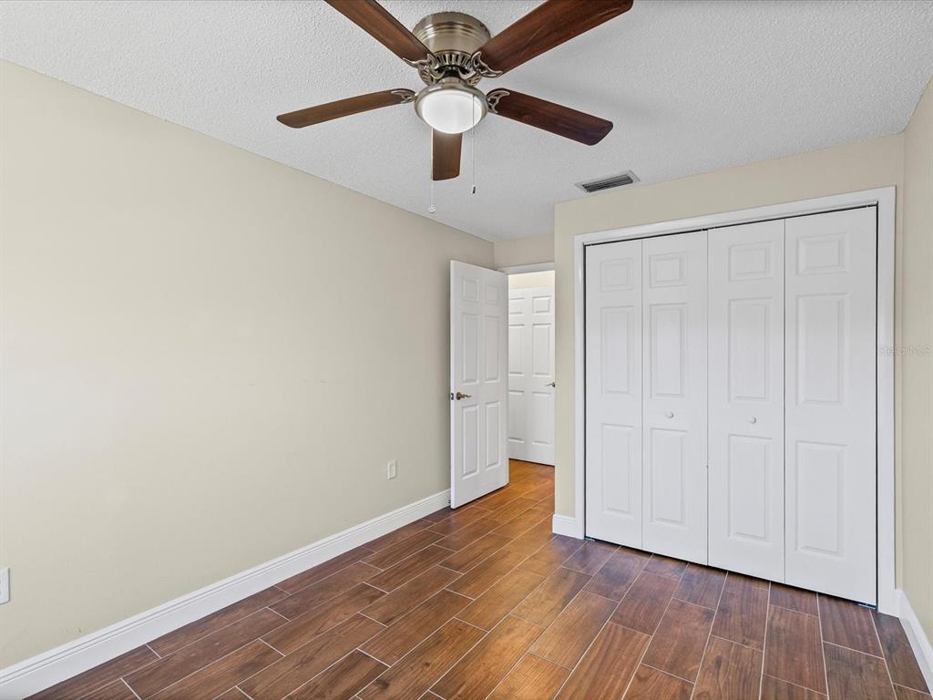 6037 Chesham Drive, Unit 7 New Port Richey, FL 34653 - Photo 19 of 29 a view of an empty room with wooden floor
