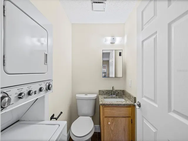 a bathroom with a granite countertop toilet sink and mirror